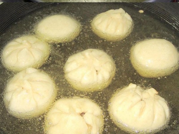 Cách làm bánh bao chiên - Cho bánh bao vào chảo dầu chiên trên bếp.