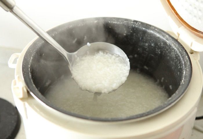 khi gạo nở bung ra thì dùng thìa nghiền nát cháo rồi thêm vào 50 ml nước dừa tươi đun tiếp cho sôi.