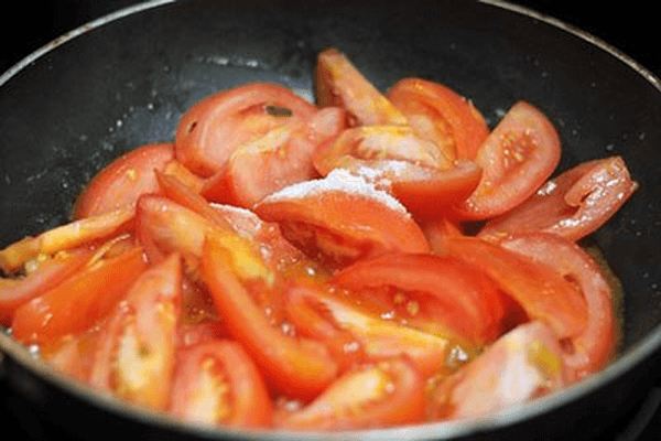 Cho cà chua vào chảo vừa xào thịt bò đảo đều khoảng 5 -10 phút