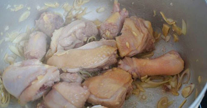 Cho thịt gà lên bếp đun nóng, sau đó cho 4 thìa canh dầu ăn vào phi thơm tỏi băm
