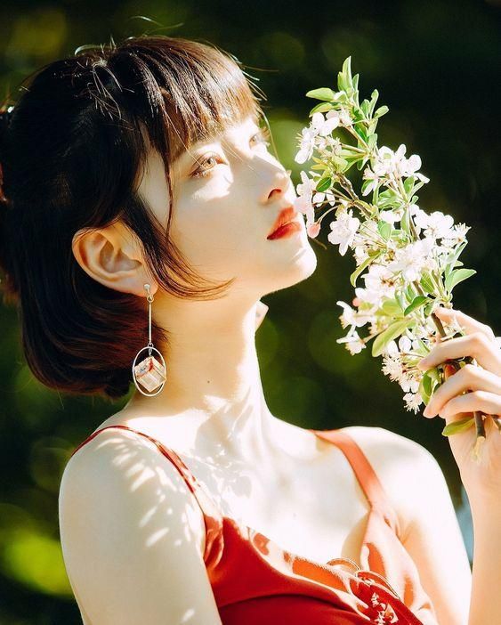Hình ảnh cô gái cầm cành hoa
